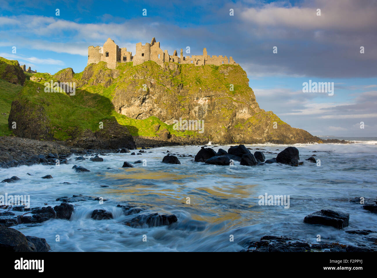 Le lever du soleil sur le château de Dunluce le long de la côte nord du comté d'Antrim, Irlande du Nord, Royaume-Uni Banque D'Images