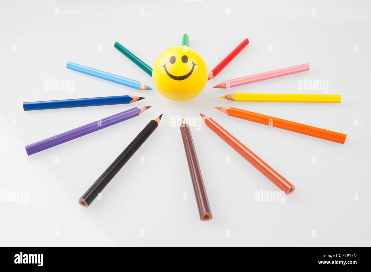 Sharp colorful crayons pointant sur smiley. Banque D'Images