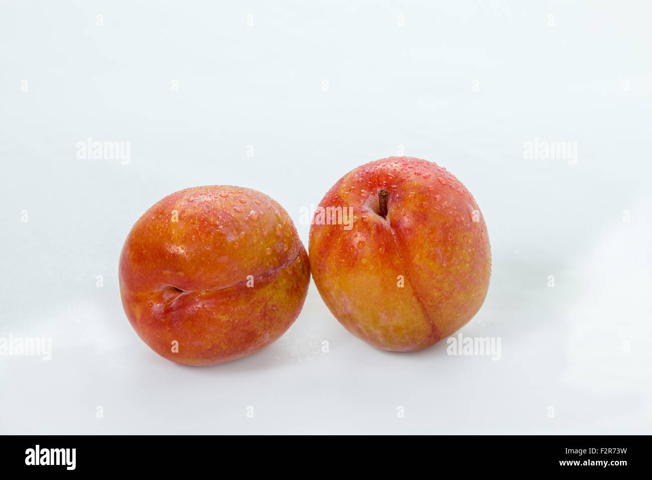 Prunes rouges isolé sur fond blanc Banque D'Images