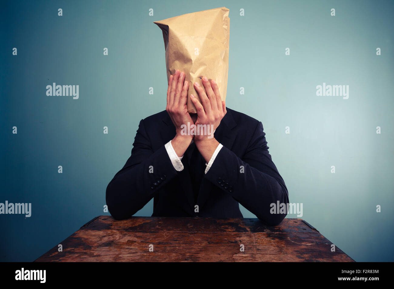 Homme déprimé avec un sac en papier sur la tête Banque D'Images