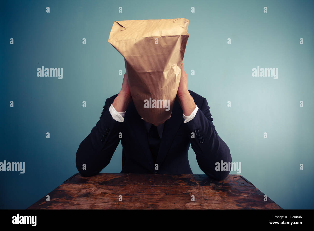 Homme triste et fatigué avec un sac en papier sur la tête Banque D'Images