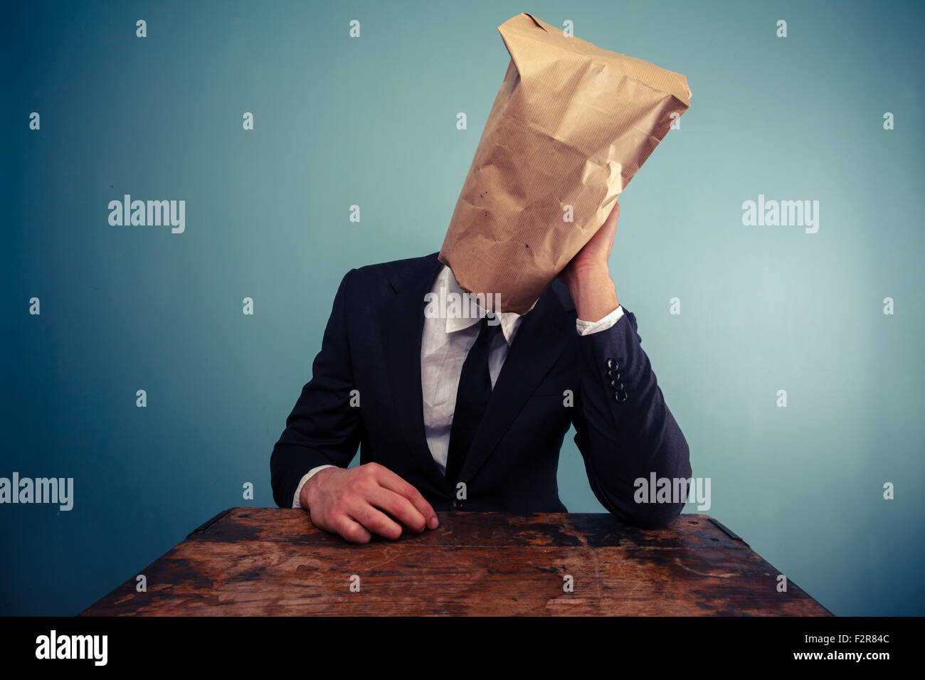 Fatigué et déprimé businessman avec un sac en papier sur la tête Banque D'Images