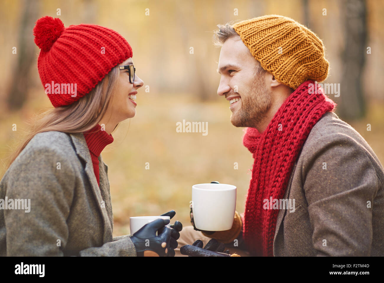 Jeune couple joyeux de parler à l'extérieur tout en prenant le thé Banque D'Images