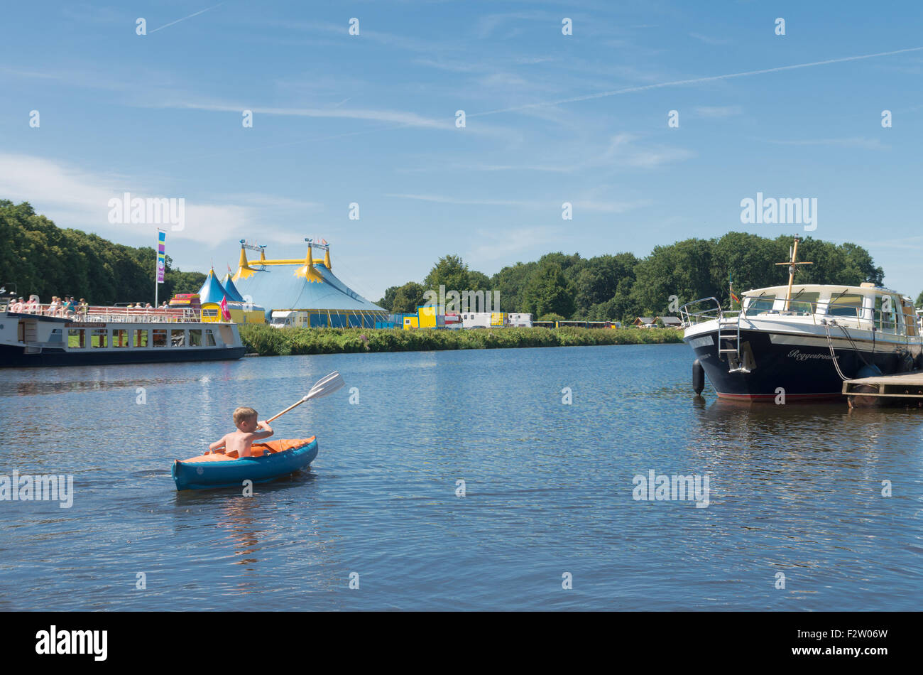 OMMEN, Pays-Bas - 9 août 2015 : Inconnu Garçon jouant avec son canot dans la rivière Regge. La zone de Regge est une maison de vacances Banque D'Images