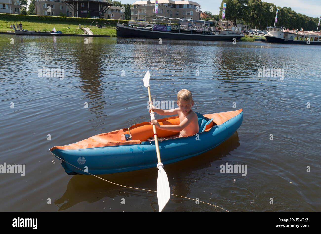 OMMEN, Pays-Bas - 9 août 2015 : Inconnu Garçon jouant avec son canot dans la rivière Regge. La zone de Regge est une maison de vacances Banque D'Images