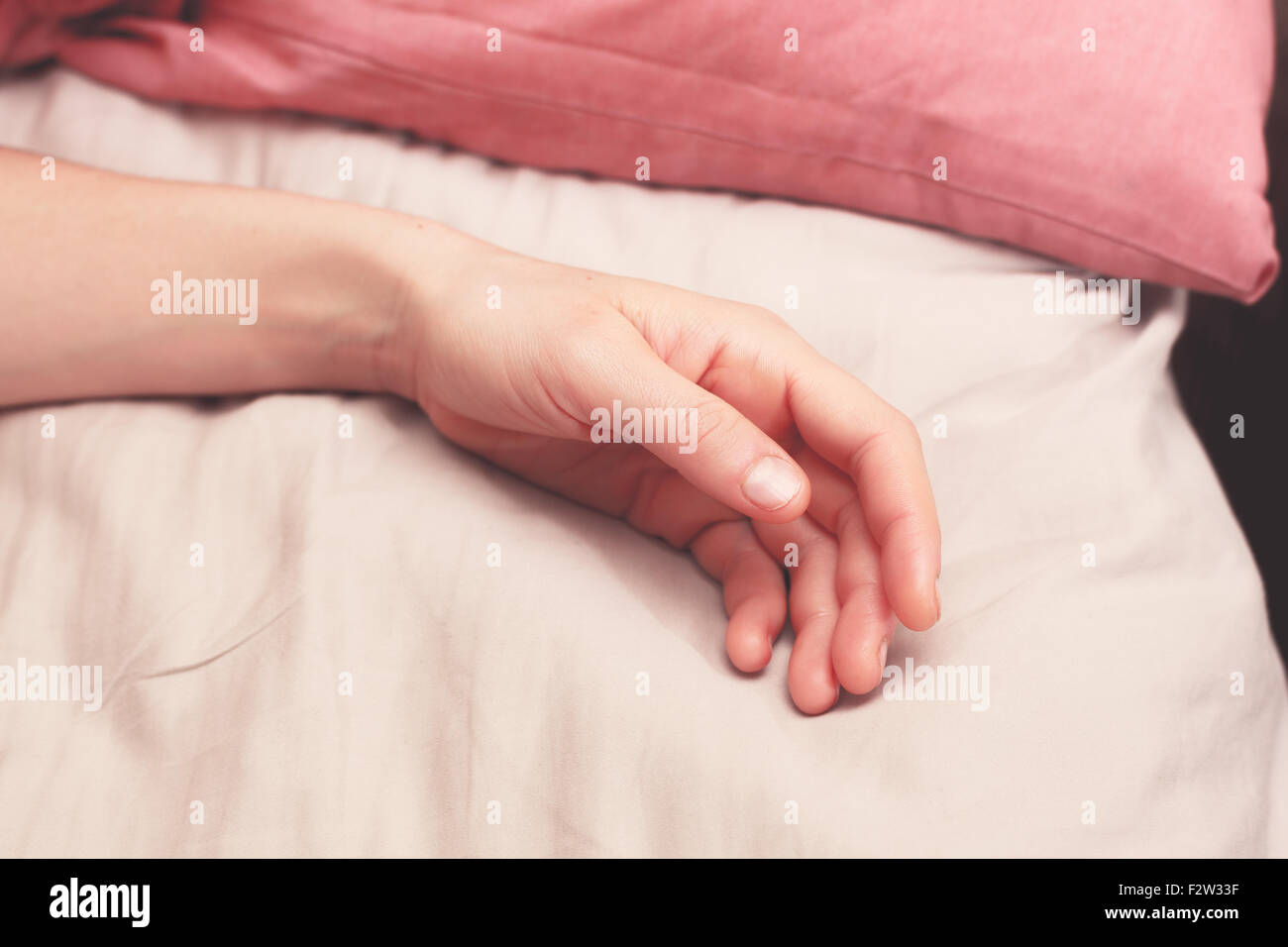 Young woman's arm dans le lit le matin Banque D'Images