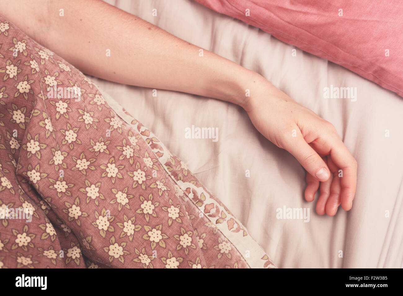 Young woman's arm dans le lit le matin Banque D'Images