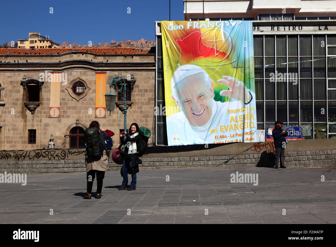 Les touristes posent pour des photos devant une bannière du Pape François en la Plaza San Francisco, La Paz, Bolivie Banque D'Images