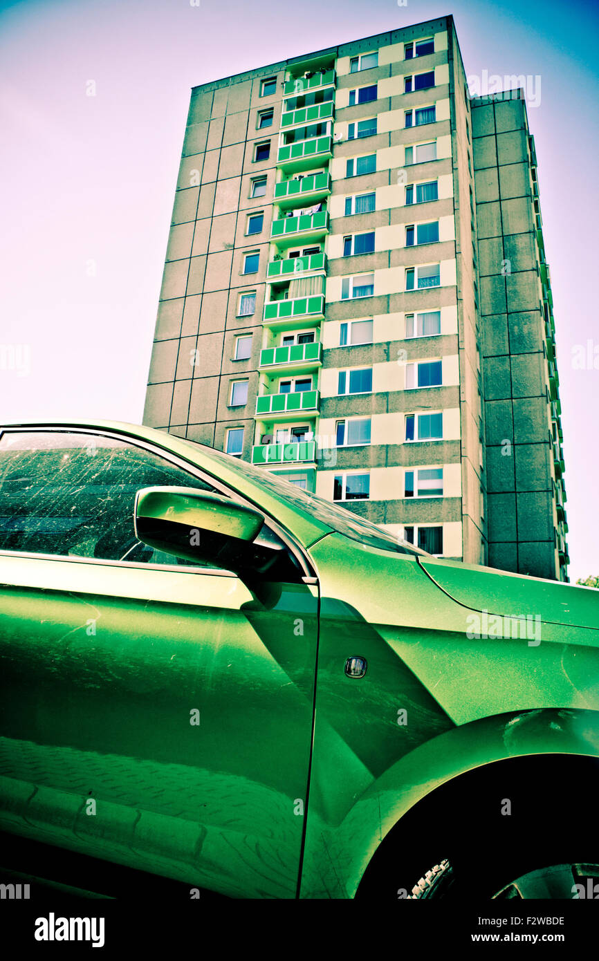 Green car en face d'un immeuble de plusieurs étages Banque D'Images