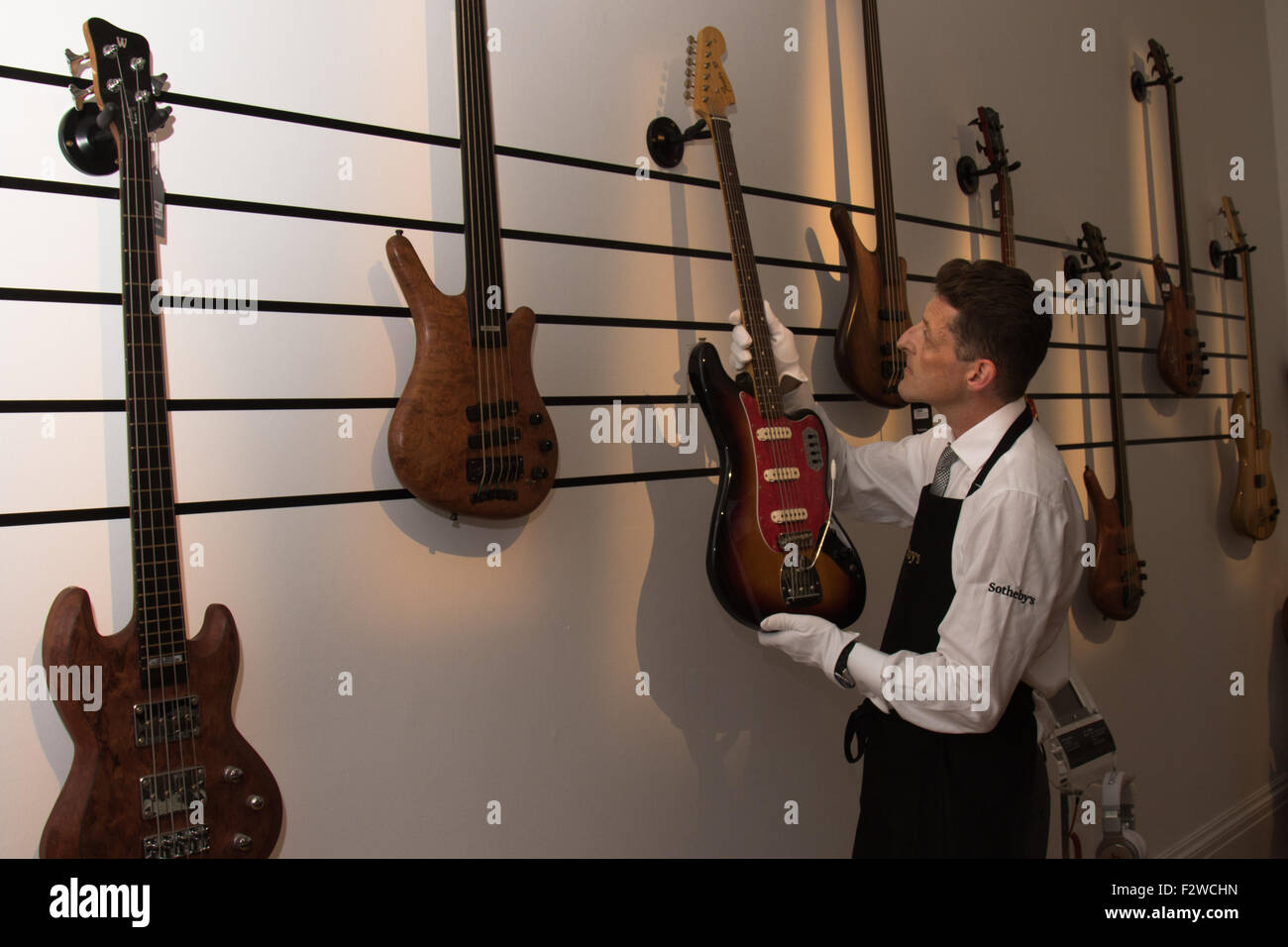 Londres, Royaume-Uni. September 24th, 2015. Un technicien de Sotheby's Gallery organise une exposition de basses propriété de Cream, Jack Bruce. Elles disposent dans les auctioneers Rock et Pop 24 Exécution de l'exposition - 28 septembre l'avant d'une vente aux enchères le 29 septembre. L'exposition rassemble des lyrics, instruments, costumes de scène et les œuvres de certains des plus grands artistes pop et rock et des groupes, y compris l'Abba, les Beatles, Bob Dylan, Pink Floyd et Bruce Springsteen. Crédit : Paul Davey/Alamy Live News Banque D'Images