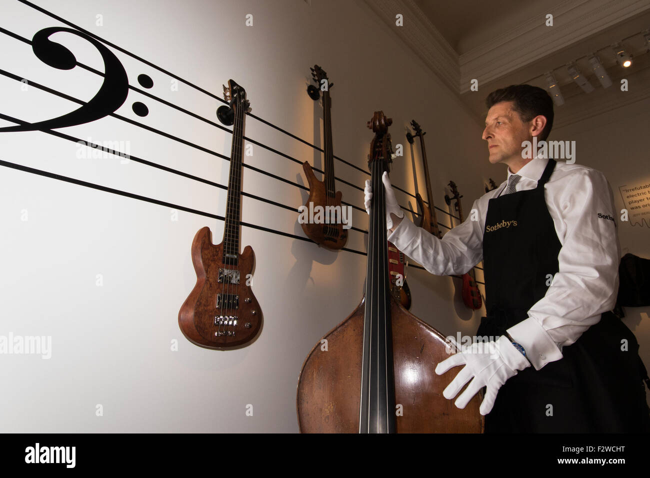 Londres, Royaume-Uni. September 24th, 2015. Un technicien de Sotheby's Gallery organise une exposition de basses propriété de Cream, Jack Bruce. Elles disposent dans les auctioneers Rock et Pop 24 Exécution de l'exposition - 28 septembre l'avant d'une vente aux enchères le 29 septembre. L'exposition rassemble des lyrics, instruments, costumes de scène et les œuvres de certains des plus grands artistes pop et rock et des groupes, y compris l'Abba, les Beatles, Bob Dylan, Pink Floyd et Bruce Springsteen. Crédit : Paul Davey/Alamy Live News Banque D'Images