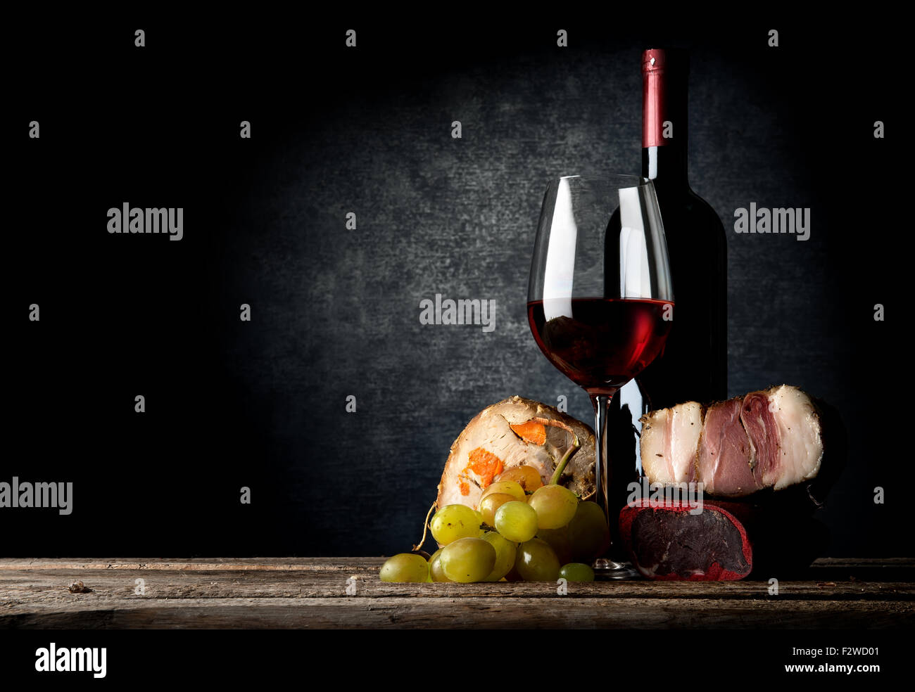 La viande et le vin rouge sur une table en bois Banque D'Images