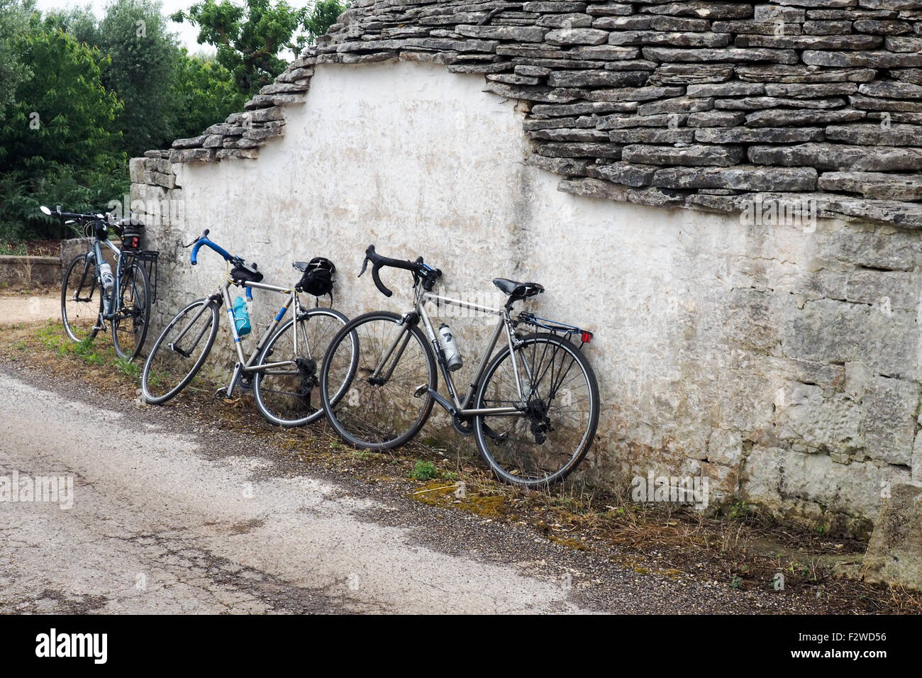 Promenade motos reposant contre un mur d'un trullo cottage. Banque D'Images
