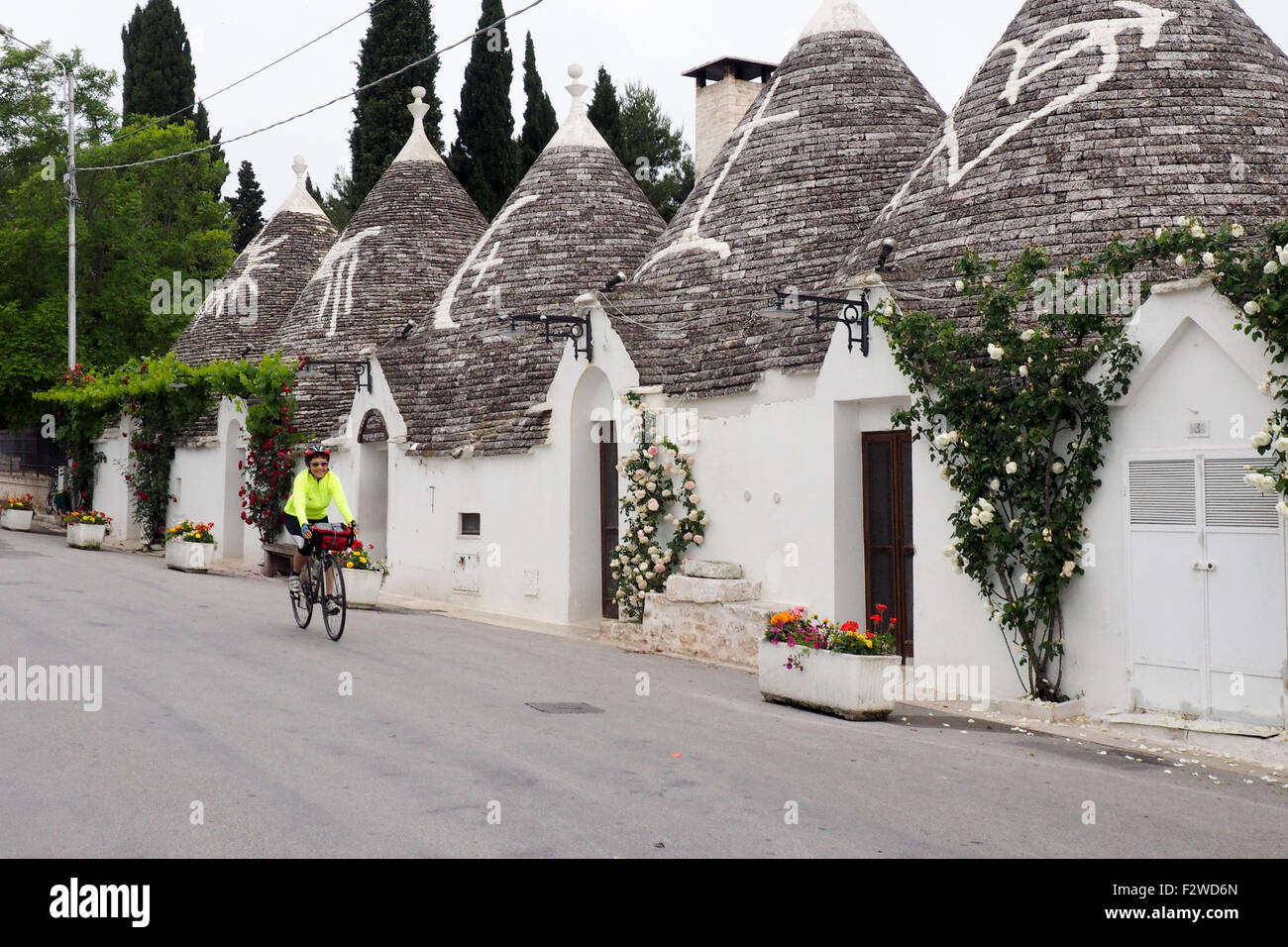 Randonnée vélo cycliste sur une rue de Trulli dans le quartier de Monti à Alberobello Banque D'Images