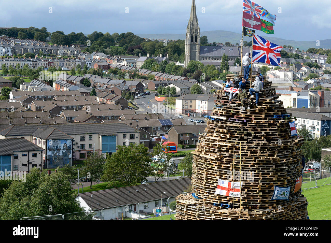 Les jeunes nationalistes debout sur un grand feu fait à partir de palettes en bois, dans le Bogside, Londonderry, en Irlande du Nord. Banque D'Images