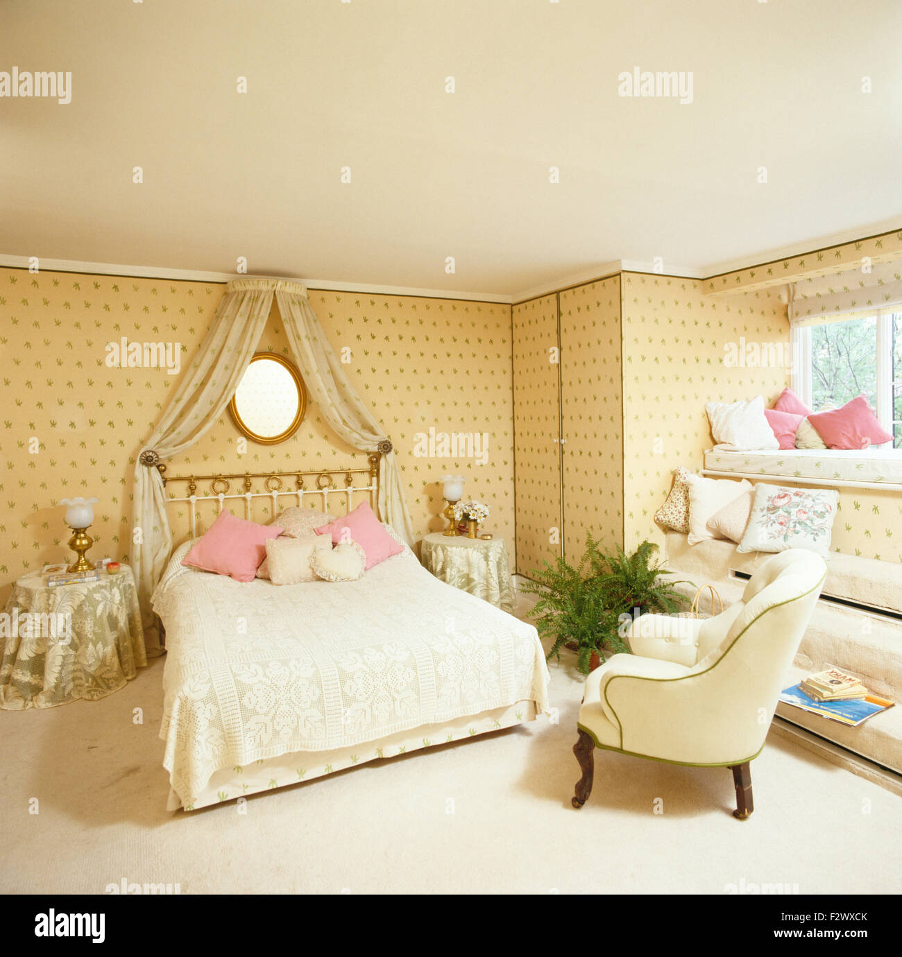 Coronet avec rideaux crème au-dessus de lit en cuivre avec un couvre-lit en  dentelle 90 chambre avec du papier peint à motifs Photo Stock - Alamy