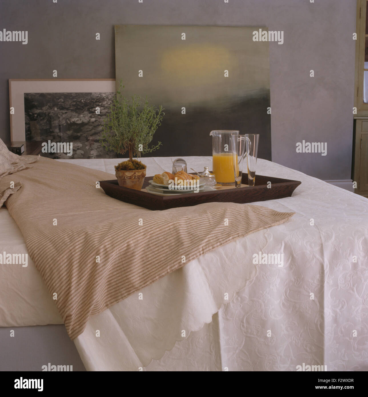 Plateau du petit déjeuner sur le lit avec couvre-lit en coton blanc chambre ville gris Banque D'Images