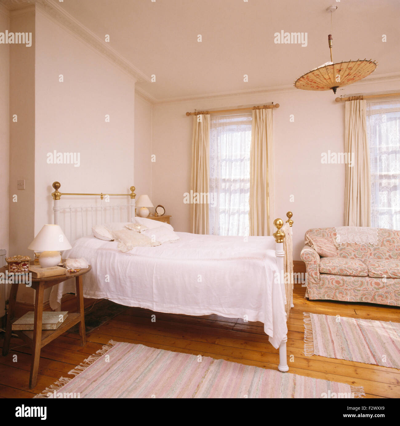 Couvre-lit en coton blanc sur laiton lit dans chambre avec 80 parasol  chinois utilisé comme un abat-jour Photo Stock - Alamy