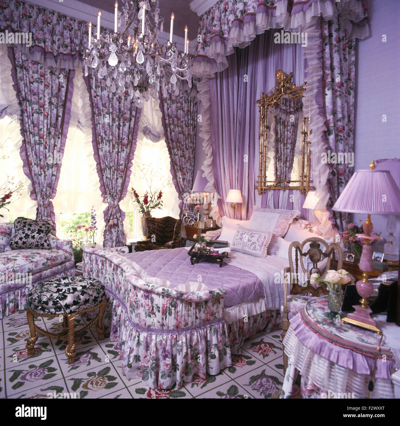 Rideaux aux motifs floraux sur windows et au-dessus de lit dans le plus haut 90 chambre mauve Banque D'Images