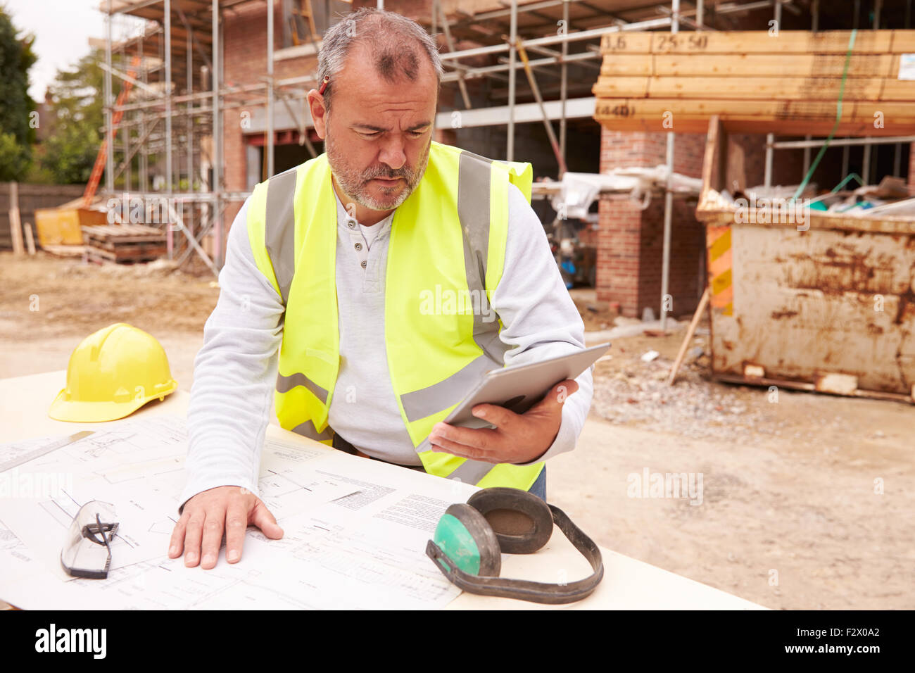 Construction Worker Using Digital Tablet sur chantier Banque D'Images