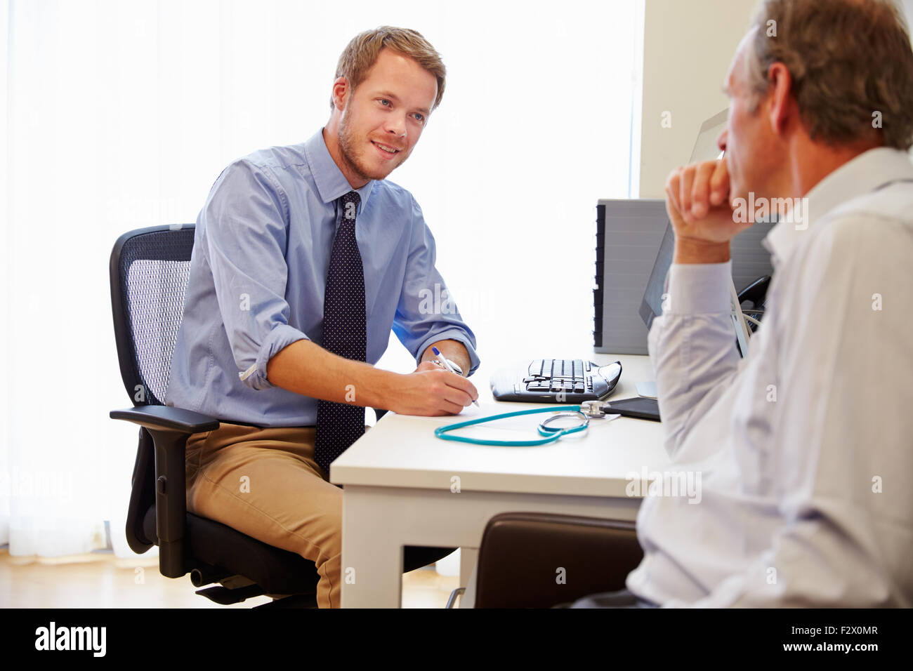 Male Patient en consultation avec le docteur In Office Banque D'Images