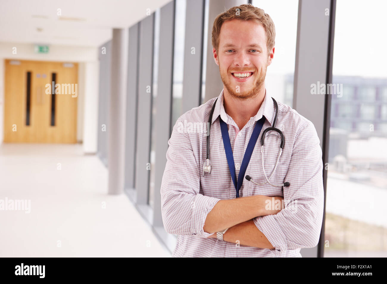 Portrait Of Male Doctor Standing In Hospital Corridor Banque D'Images