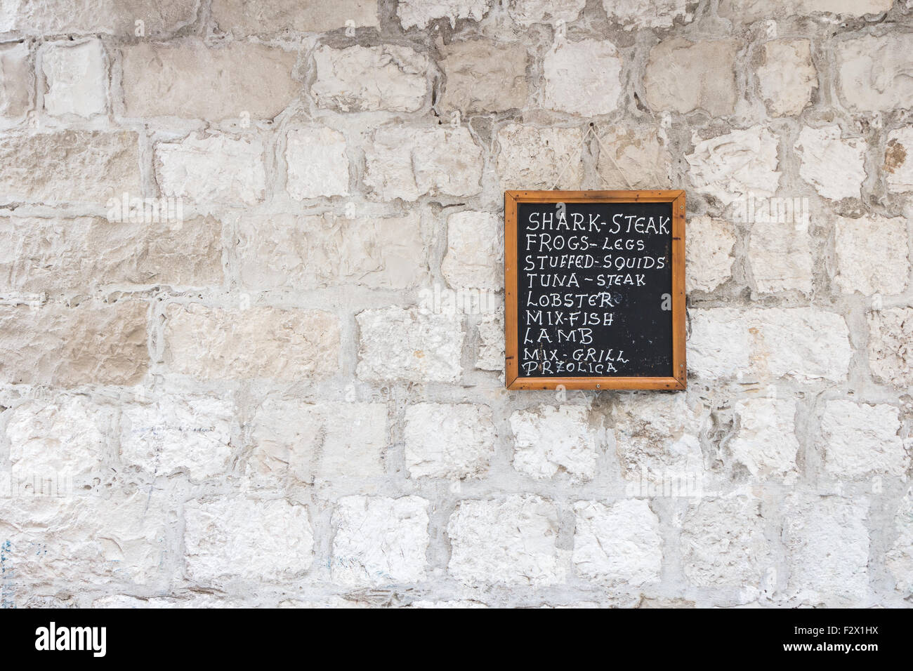 Restaurant à Chalk board avec liste de plats sur un mur de pierre. Banque D'Images