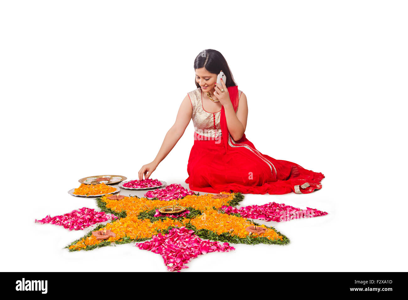 1 Femme adulte indien Diwali Festival Conception Rangoli et parler Mobile Phone Banque D'Images 1 Femme adulte indien Diwali Festival Conception Rangoli et parler Mobile Phone Banque D'Images
