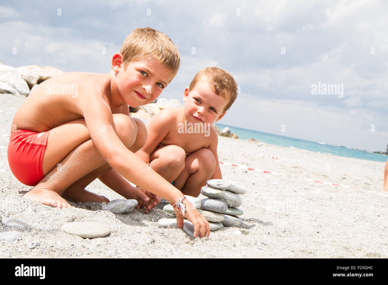 Deux petits frères jouant sur la plage Banque D'Images
