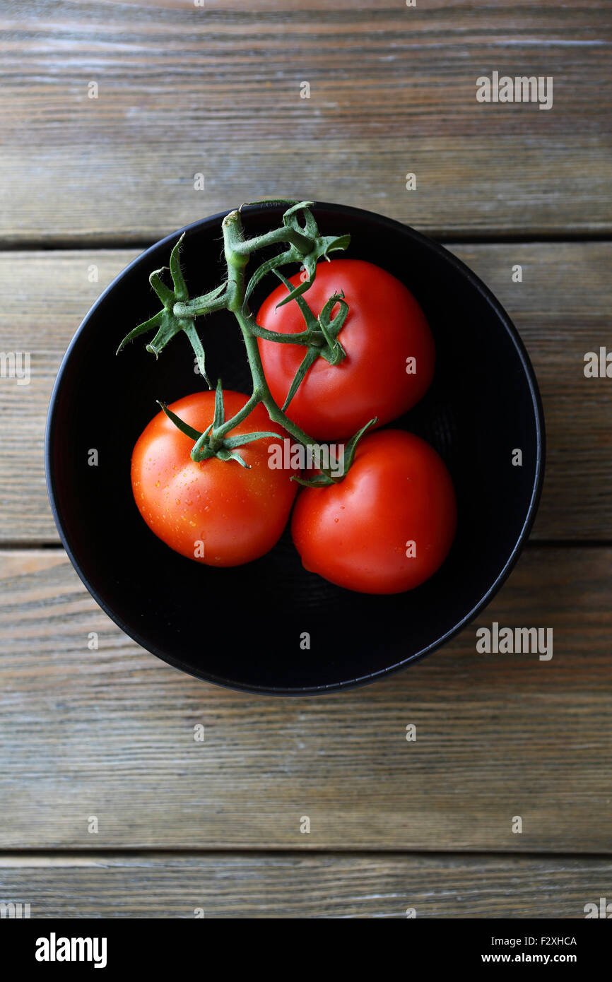 Les tomates rouges en noir bol, vue d'en haut Banque D'Images