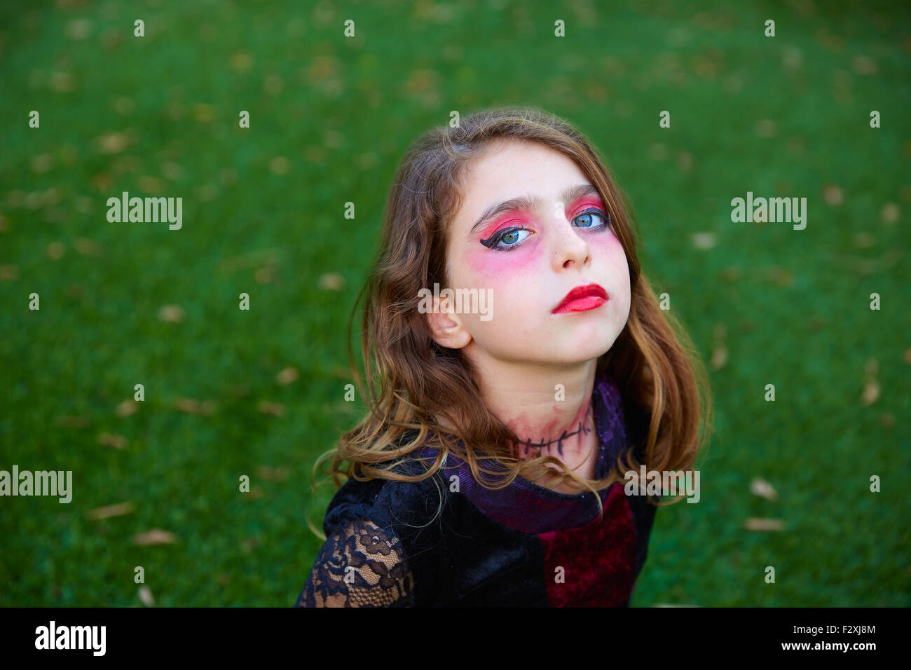 Maquillage Halloween kid girl yeux bleus dans une pelouse arrière Banque D'Images