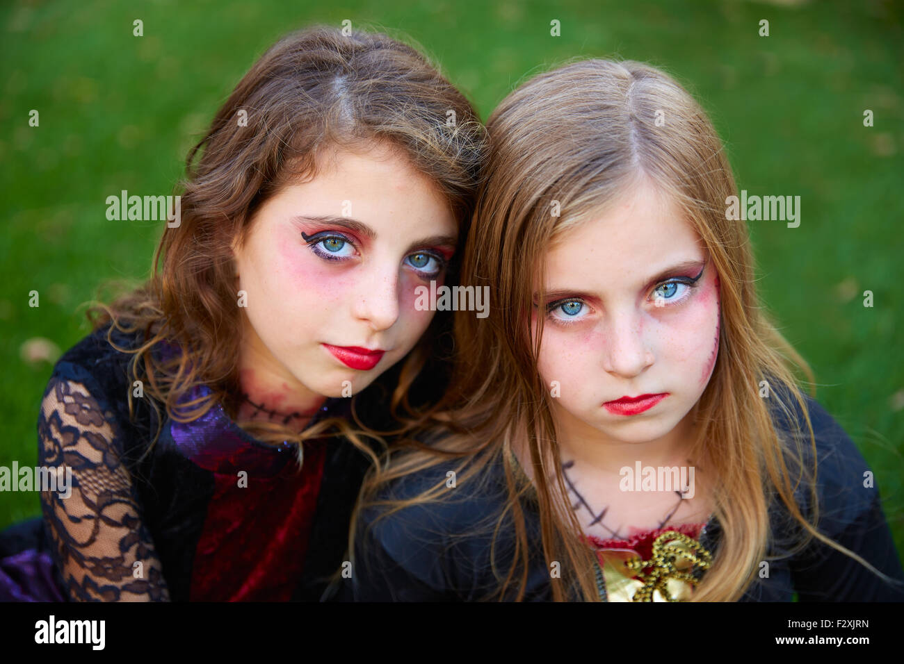 Maquillage Halloween petite sœur pour les yeux bleus dans une pelouse arrière Banque D'Images