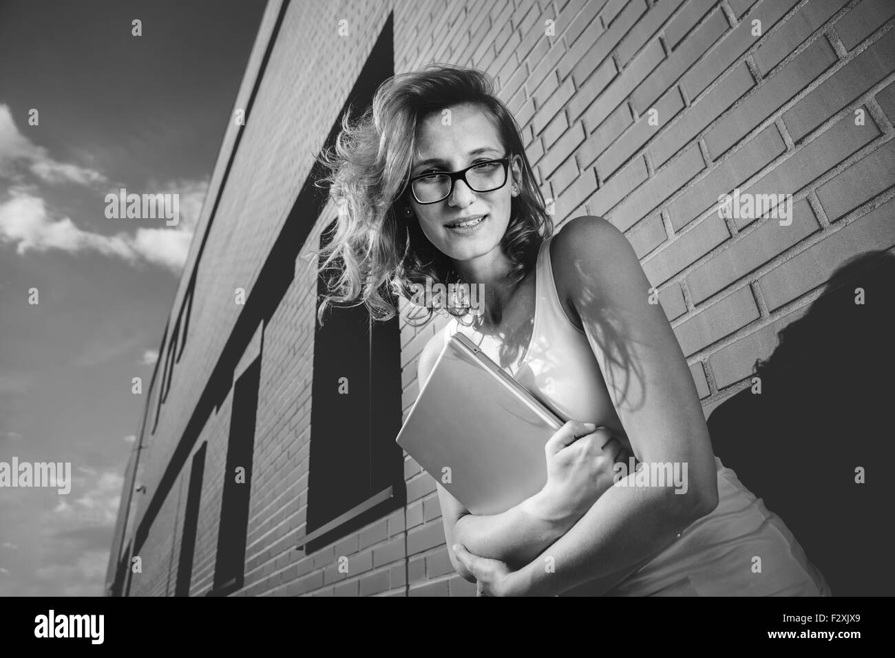 Portrait of female student l'extérieur à côté de la bibliothèque le mur de brique Banque D'Images