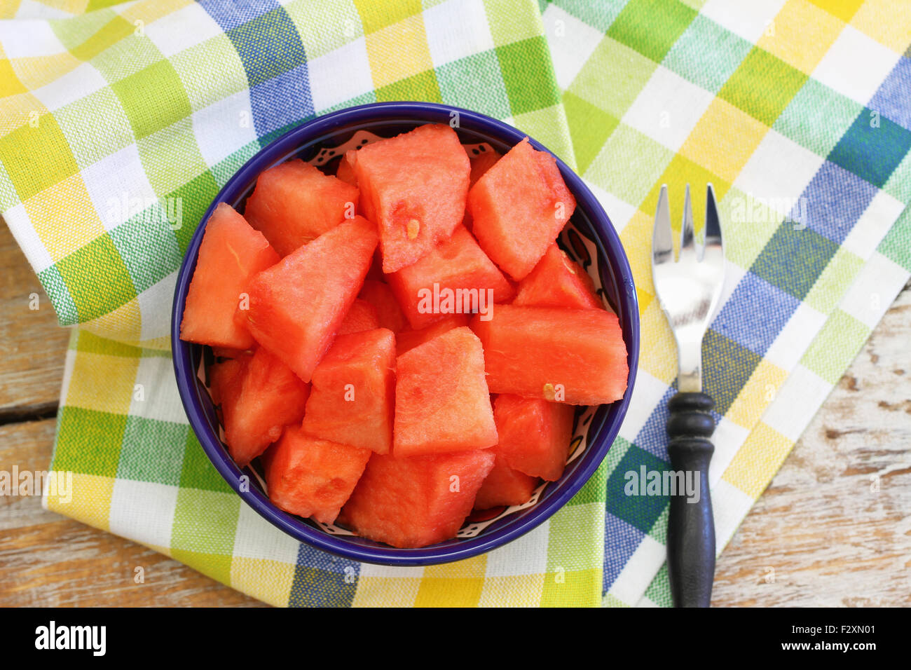 Cubes de melon dans le bol sur le tissu à carreaux Banque D'Images