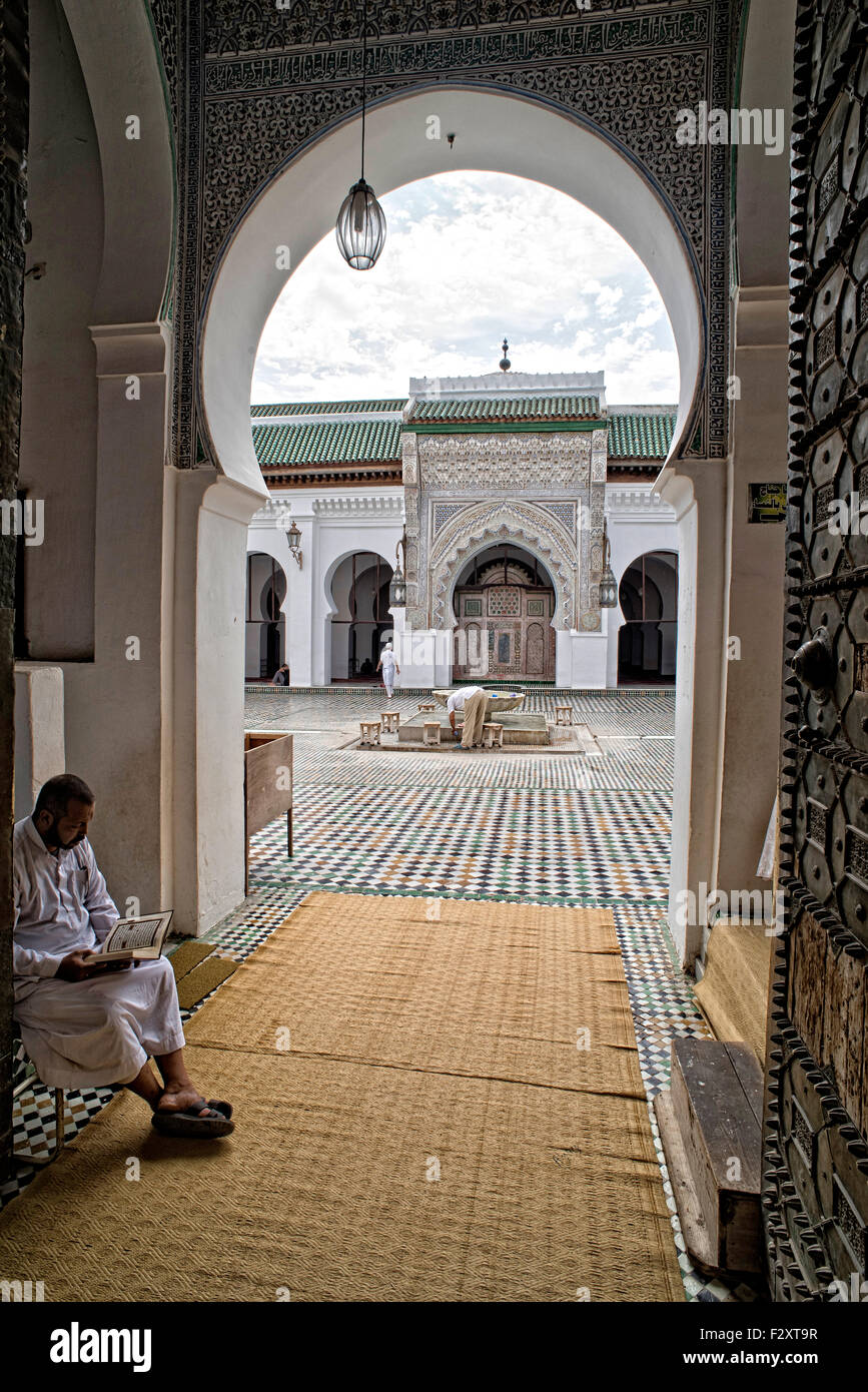 Lire le Coran l'homme dans l'entrée de la mosquée de Kairaouine, Fes, Maroc Banque D'Images