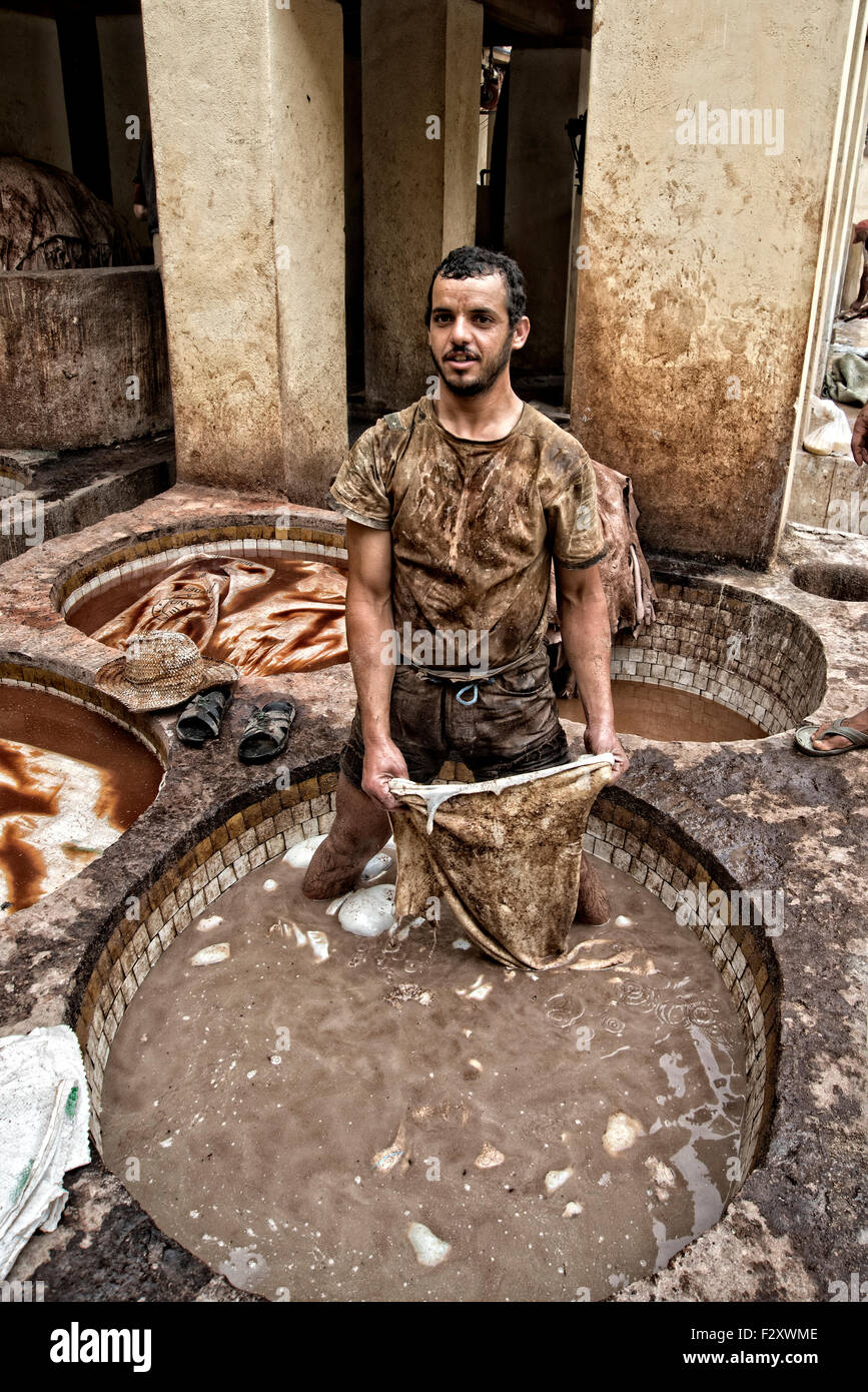 Travailleur du cuir à la tannerie Chouarra à Fez, Maroc, debout dans une cuve de solution d'adoucissement en cuir. Banque D'Images
