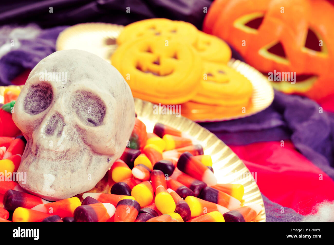 Libre de la plaque avec les bonbons de l'Halloween et un crâne, et quelques cookies en forme de citrouille avec ornements effrayant dans l'arrière-plan, s Banque D'Images