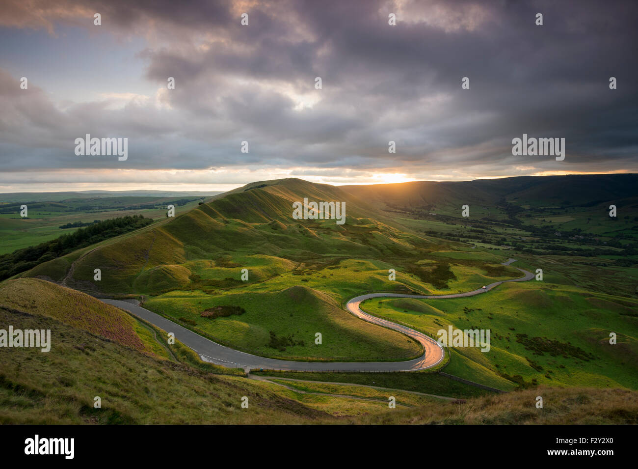 La route sinueuse menant à Edale avec Rushup Edge au coucher du soleil, parc national de Peak District, Derbyshire Banque D'Images