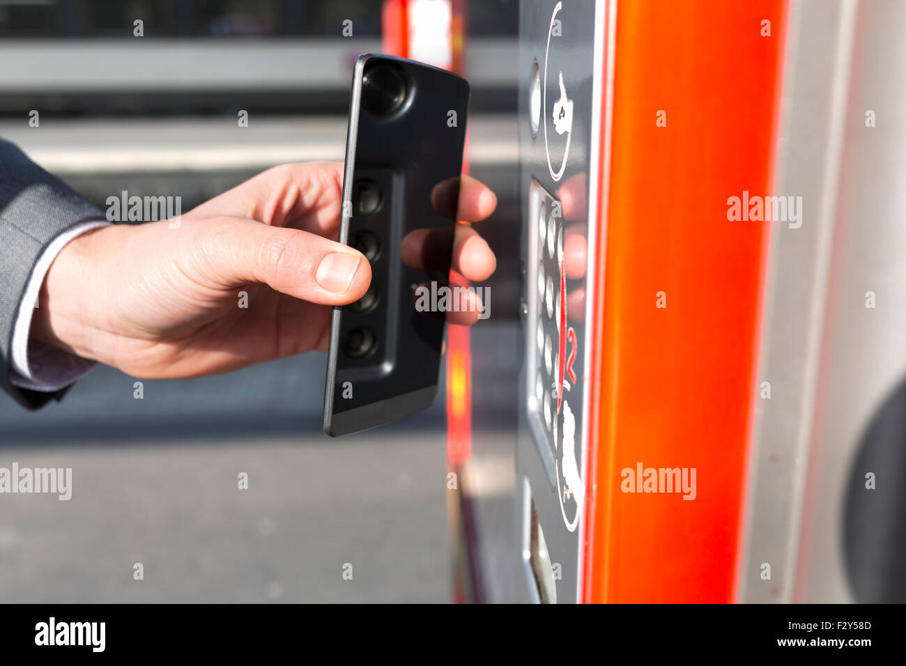L'homme doit payer son ticket de transport avec son téléphone mobile sur la plate-forme. NFC Banque D'Images