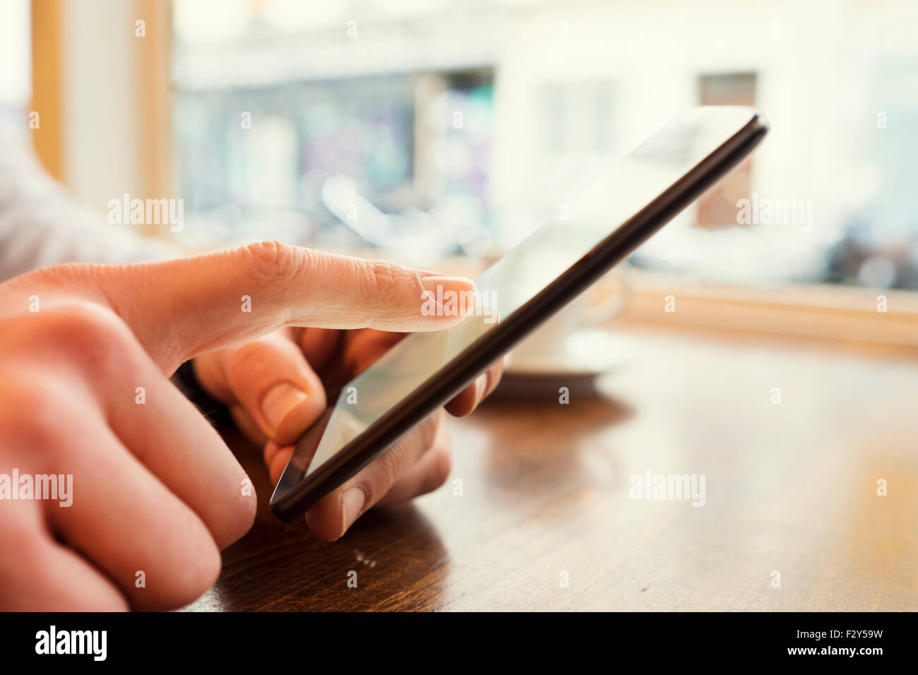 Homme dans un bar à l'aide téléphone portable. arrière-plan de la fenêtre. Filtre Vintage Banque D'Images