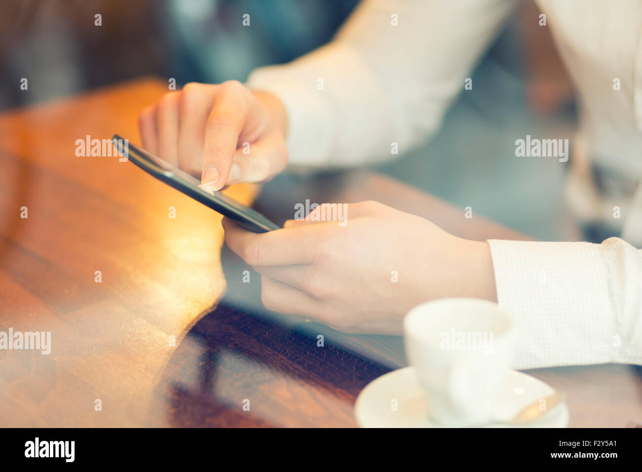 L'homme dans un bar à l'aide de téléphone mobile. Filtre Vintage Banque D'Images