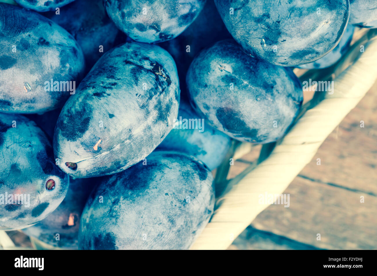 Les prunes bleu frais dans un panier en osier vue supérieure Banque D'Images