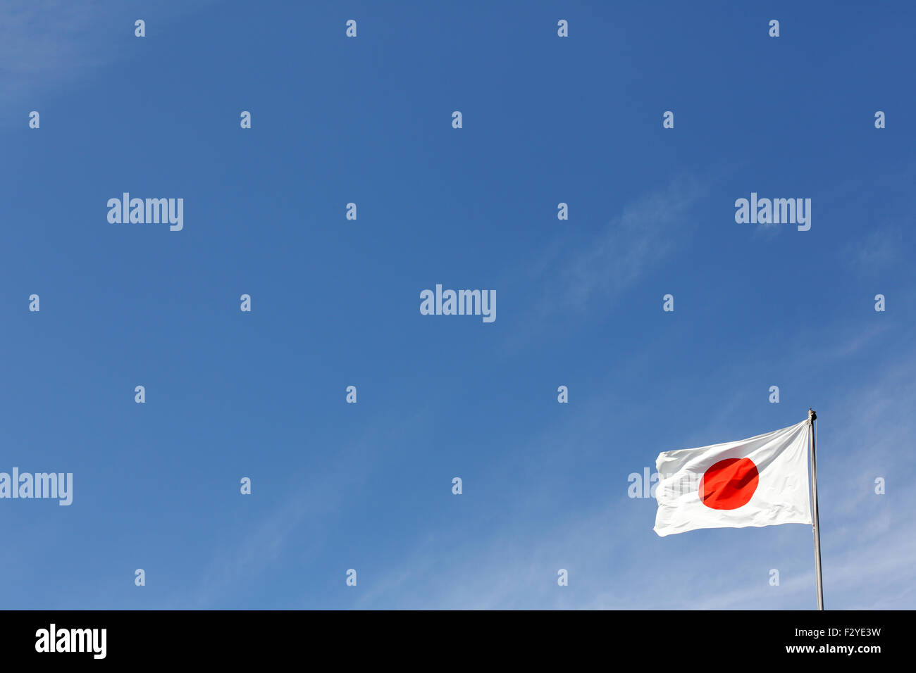 Drapeau japonais en vent contre ciel bleu clair Banque D'Images