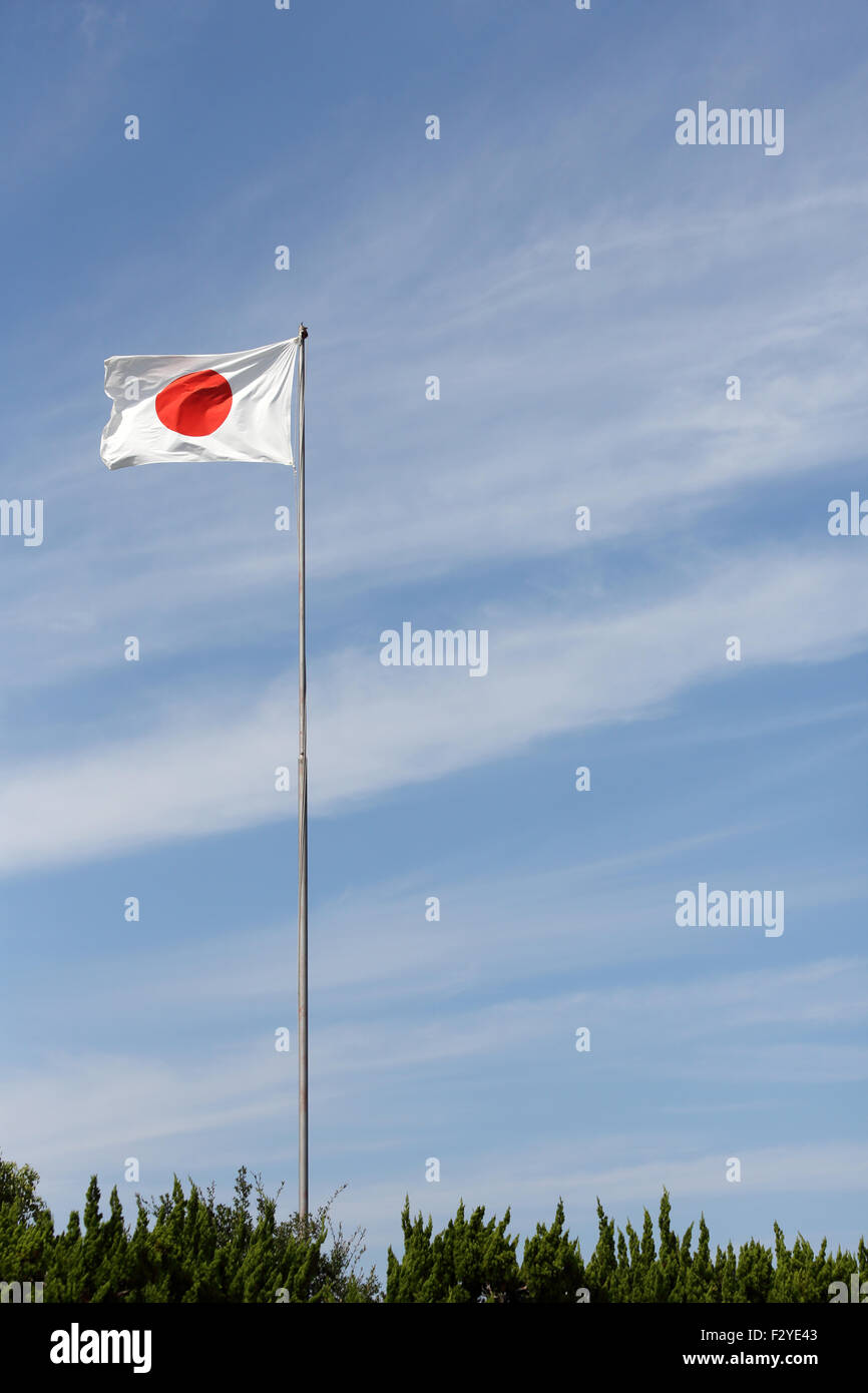 Drapeau japonais en vent contre un ciel bleu Banque D'Images