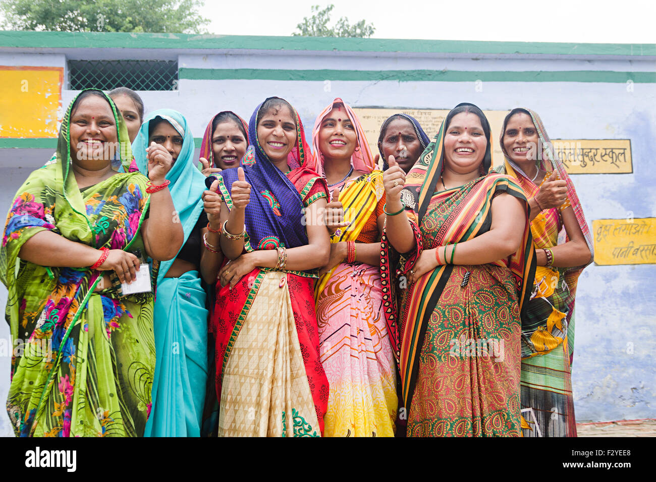 Groupe villageois rural indien foule femme shwoing article voisin Thumbs Up Banque D'Images