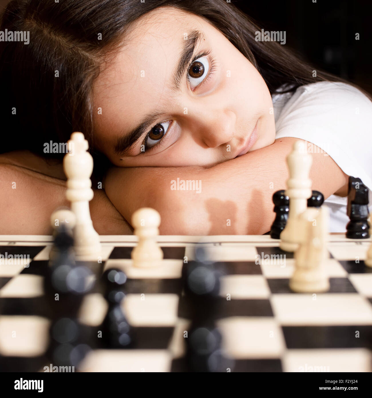 Belle petite fille jouant aux échecs concentré Banque D'Images
