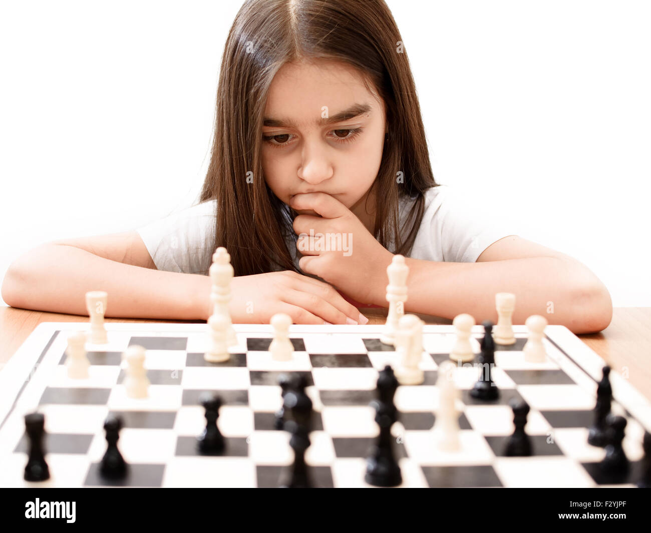 Belle petite fille jouant aux échecs concentré Banque D'Images