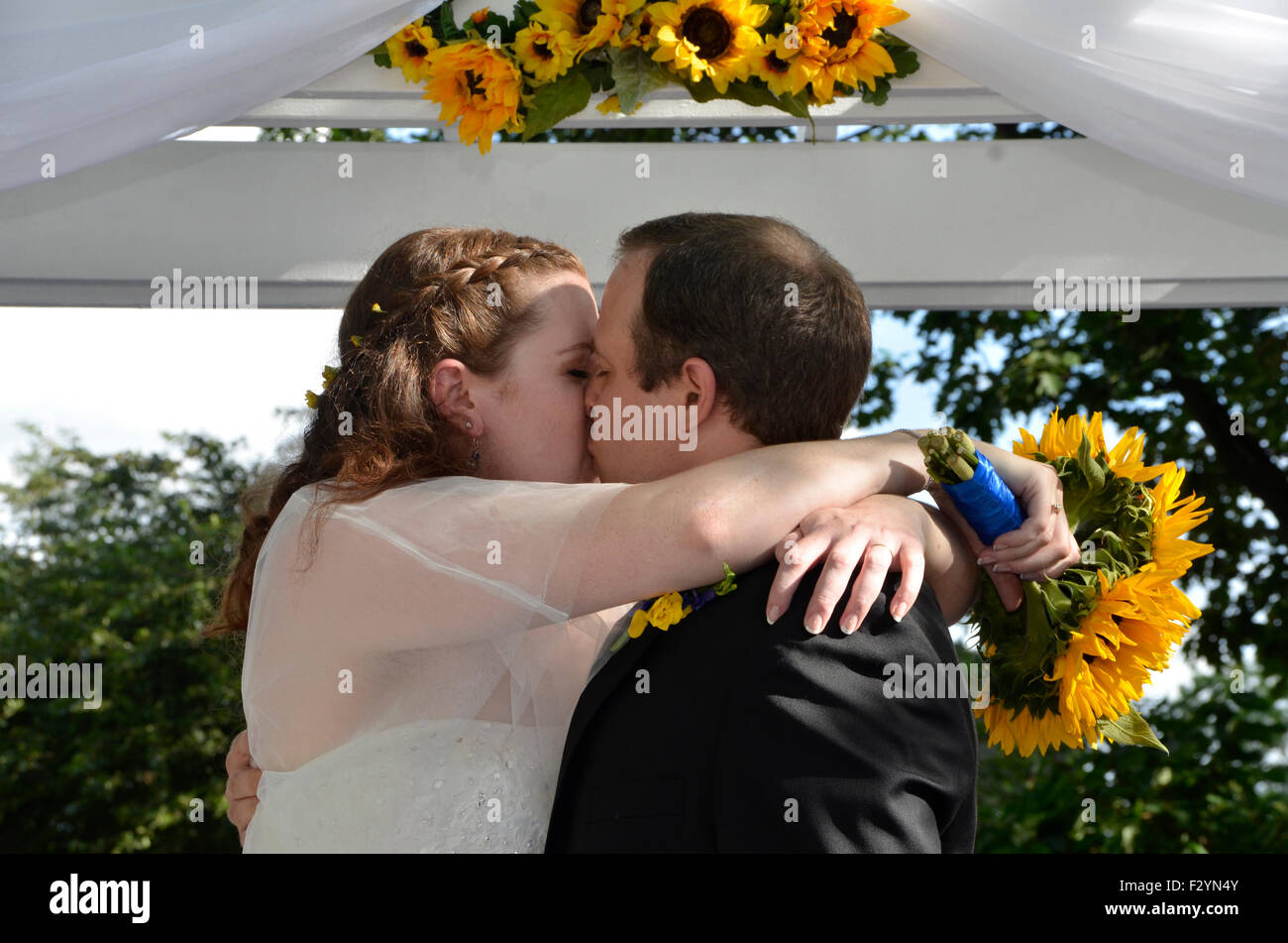 Mari et femme ont un baiser passionné à leur mariage Banque D'Images