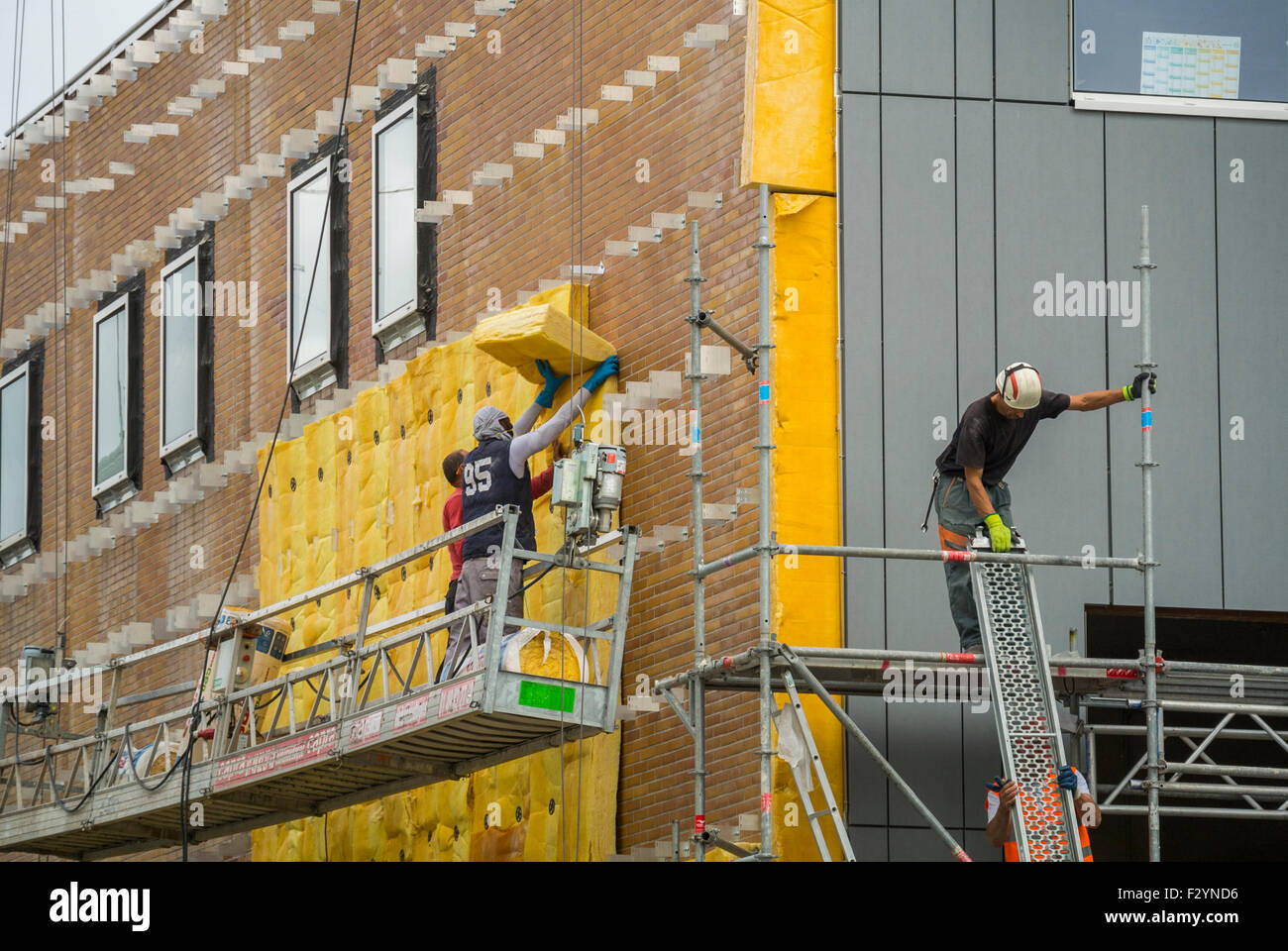 Paris, France, travailleurs sur le chantier de construction de bâtiments, ajout de l'installation d'isolation murale en fibre de verre au bâtiment existant, rénovation de l'architecture des bâtiments écologiques durables, durabilité des travailleurs de la construction, nouvelle construction, matériaux de construction durables, bâtiment vert moderne, bâtiments rénovés économes en énergie, emplois verts, bâtiments respectueux de l'environnement Banque D'Images