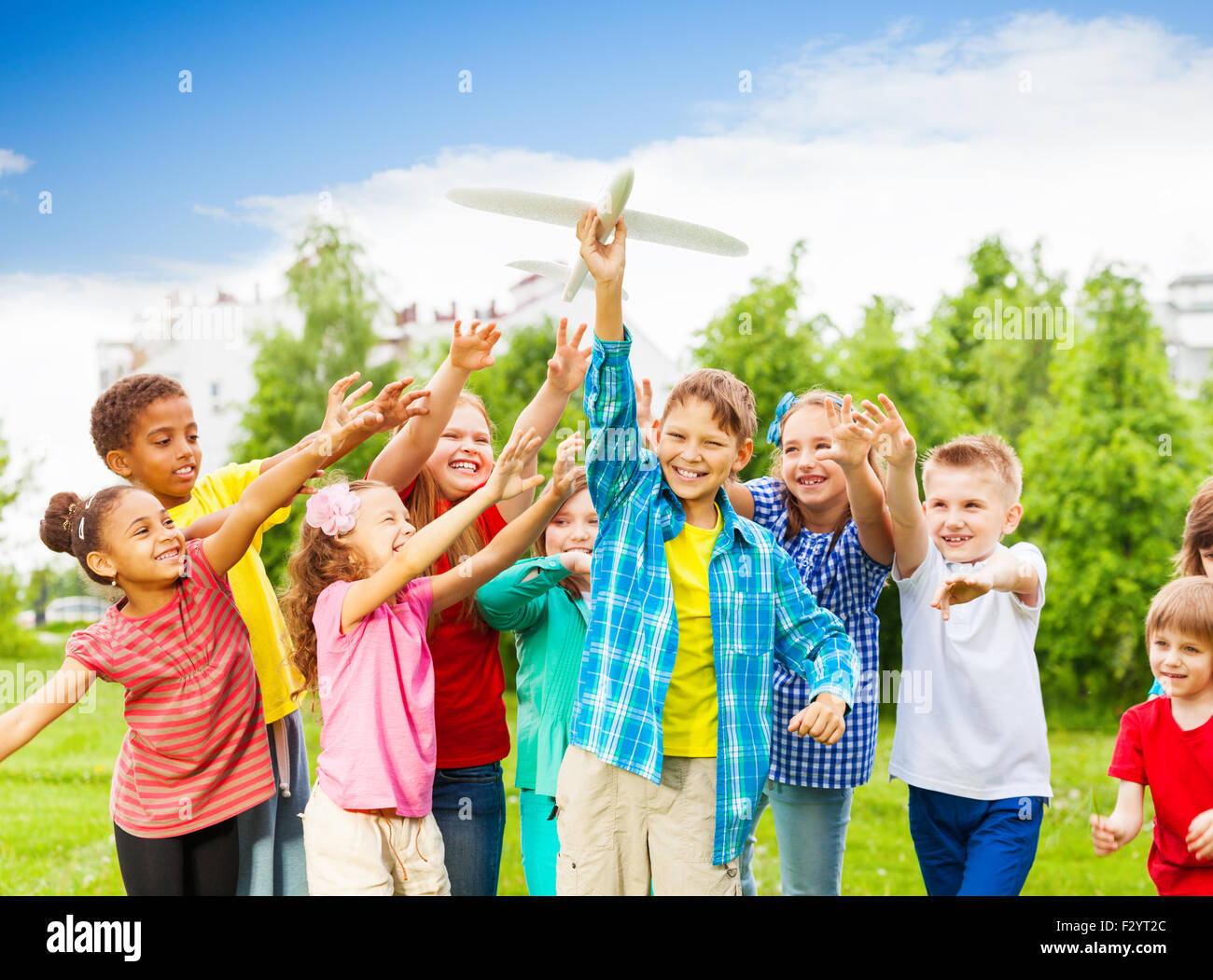 Les enfants arrivant après jouet avion blanc avec des bras Banque D'Images